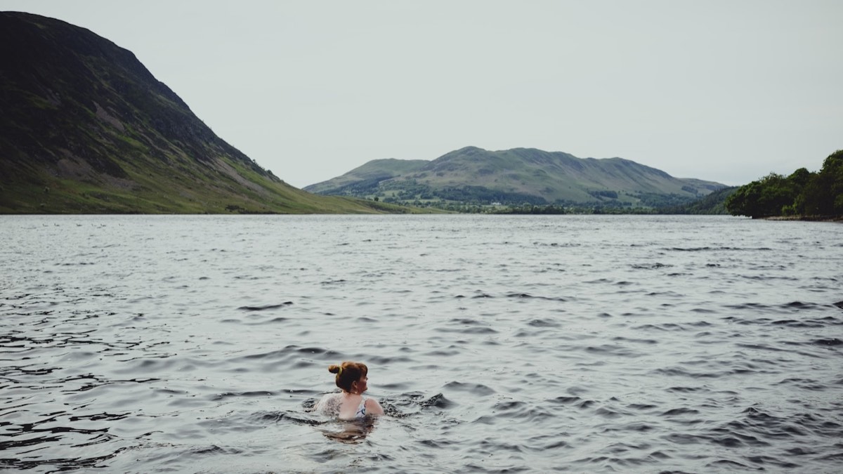 A person taking a cold swim in a mountain lake